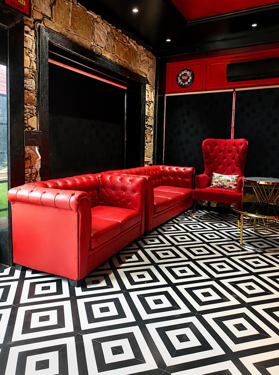 Red chesterfield sofas on a black and white geometric floor