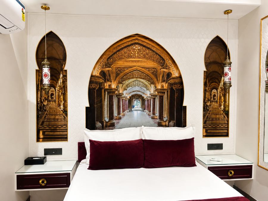 Bed beneath a painted palace-corridor arch