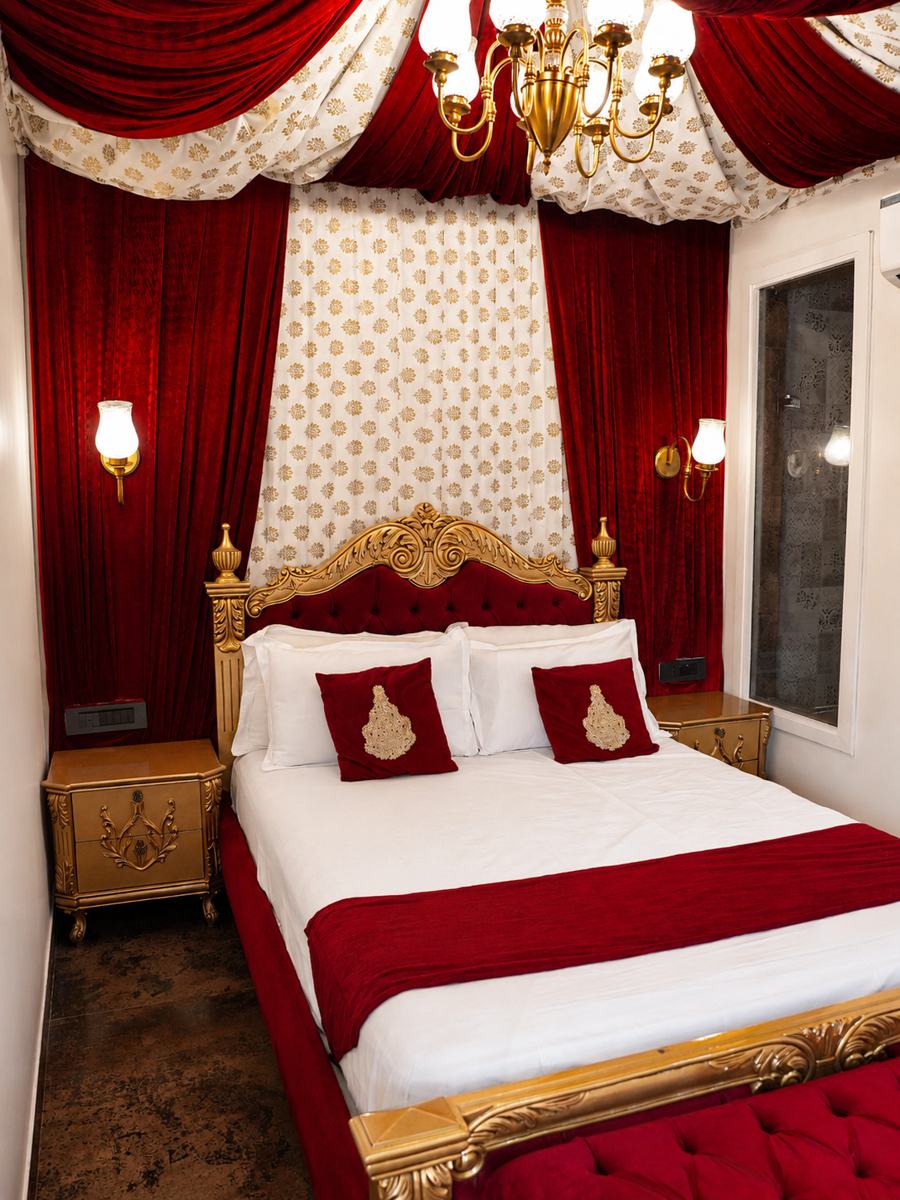 Red velvet canopy over a carved gold bed